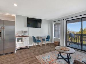 a living room with a kitchen and a table with chairs at Oceanview Bliss in Tybee Island