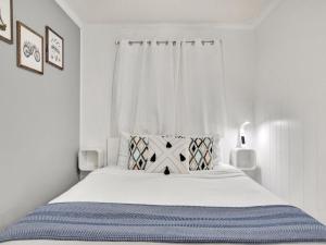 a white bedroom with a bed and a window at Oceanview Bliss in Tybee Island