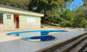 ein Swimmingpool vor einem Haus in der Unterkunft Chácara Recanto dos Lagos in Cotia