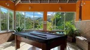 Großes Zimmer mit Billardtisch und Fenstern in der Unterkunft Chácara Recanto dos Lagos in Cotia
