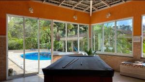 Großes Zimmer mit Pool und Tisch in der Unterkunft Chácara Recanto dos Lagos in Cotia
