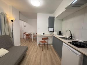 a kitchen with a couch and a table with chairs at Estudios Areal in Vigo