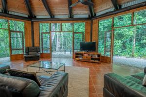Una sala de estar con sofás y un televisor de pantalla plana. en Daintree Cascades, en Cape Tribulation