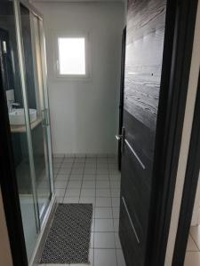a bathroom with a shower and a door with a sink at Studio indépendant in Yvré-lʼÉvêque +4 photos