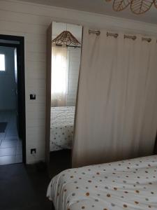 a mirror next to a bed in a bedroom at Studio indépendant in Yvré-lʼÉvêque