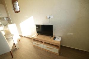 Una sala de estar con un televisor de pantalla plana sobre una mesa. en Apartmani pod Durmitorom, 
