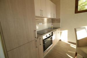 Una cocina con gabinetes blancos y un fregadero. en Apartmani pod Durmitorom, 