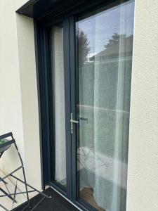 a sliding glass door with a chair in front of it at Cosy studio Noha in Thonon-les-Bains