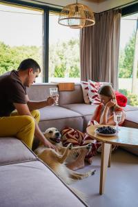 a man and a woman sitting in a living room with a dog at W POLACH in Nałęczów