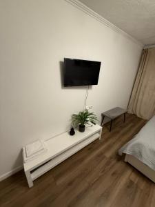 een witte kamer met een tv aan de muur bij Gregors is waiting for you in Daugavpils