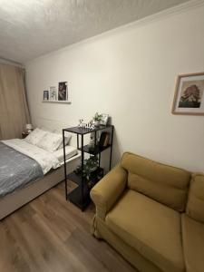 een woonkamer met een bank en een bed bij Gregors is waiting for you in Daugavpils
