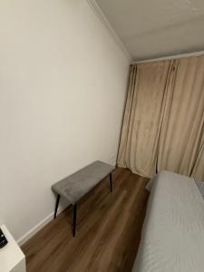 een kleine slaapkamer met een bankje naast een bed bij Gregors is waiting for you in Daugavpils