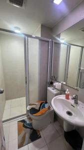 a bathroom with a toilet and a sink at Pixel Studio - Azure Residences Staycation in Sampong