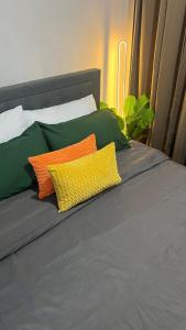 a bed with four colorful pillows on it at Pixel Studio - Azure Residences Staycation in Sampong