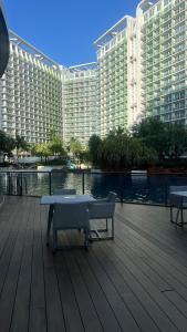 a large building with a table and benches on a deck at Pixel Studio - Azure Residences Staycation in Sampong