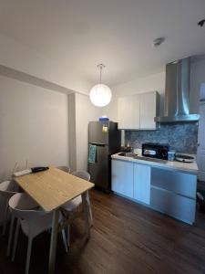 a kitchen with a wooden table and a refrigerator at Pixel Studio - Azure Residences Staycation in Sampong