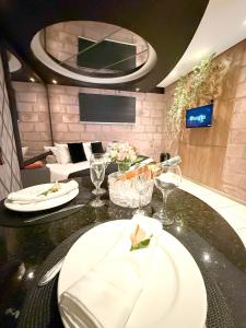 een eetkamer met een tafel met borden en wijnglazen bij Hotel Motel Paradiso - Panambi-RS in Tabapira +10 foto's