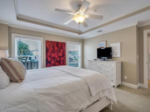 a bedroom with a white bed and a ceiling fan at Silver Seas 103 in Tybee Island