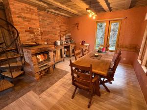 a dining room with a table and a fireplace at Pirts māja Lilijas in Baldone