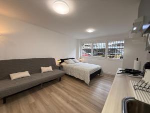 un soggiorno con un divano e un letto di Estudios Areal a Vigo