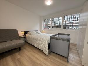 una camera da letto con un letto, un divano e una finestra di Estudios Areal a Vigo