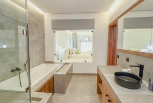 Oulad AkkouにあるLoft N 38, Cherifiaの浴槽、洗面台、鏡のあるバスルーム +27枚の写真