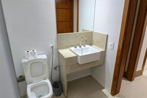 un baño con inodoro y lavabo en Center Hotel, en Duque de Caxias