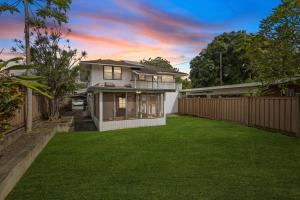 a house with a lawn in front of a fence at Hale Kulamanu in Hauula