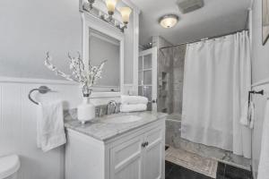 a white bathroom with a sink and a shower at Hale Kulamanu in Hauula