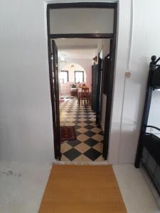 a hallway leading to a living room with a checkered floor at Arch Guesthouse - Dorm for Budget Travelers in Tangier in Tangier