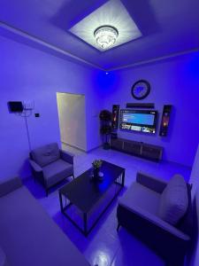 a purple living room with couches and a tv at Modern Stay in Nouakchott