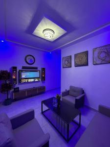 a living room with purple lighting and a tv at Modern Stay in Nouakchott