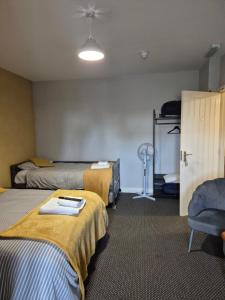 a hotel room with two beds and a chair at Rooms at number 4 in North Walsham