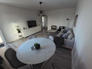 a living room with a table and a couch at Whole 3-room apartment, 10 min from malmo C & 2 min from shops in Malmö