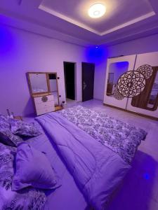 a bedroom with a large bed with purple sheets at Modern Stay in Nouakchott +5 photos