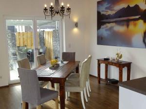 comedor con mesa de madera y sillas en Ferienwohnung am Weinberg, en Ostrach