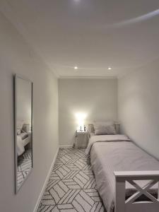 une chambre avec un grand lit et un miroir dans l'établissement Cozy 2BD apartment in Central Bergen, à Bergen