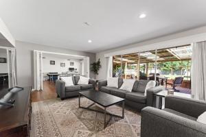 a living room with couches and a table at Rest & Play- Fire pit, Grill, PingPong- Walk 2 LSU in Baton Rouge