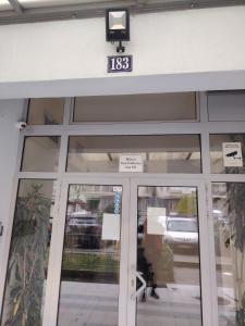 a front door of a building with a clock above it at Sicilija apartment in Podgorica