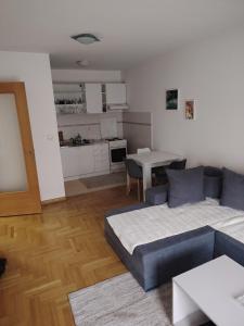 a living room with a couch and a table and a kitchen at Sicilija apartment in Podgorica