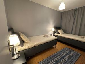 Kleines Zimmer mit 2 Betten und einem Teppich in der Unterkunft Noah Longstay Bygatan in Västerås