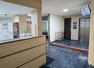 Un vestíbulo con una puerta de cristal con el suelo dañado. en Center Hotel, en Duque de Caxias