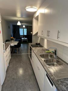 eine Küche mit weißen Schränken und einer Spüle in der Unterkunft Noah Longstay Bygatan in Västerås