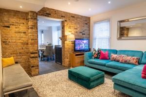 贝克斯利Bright & Comfy Single Room in Bexley Village的客厅设有蓝色的沙发和砖墙