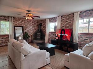 sala de estar con 2 sofás blancos y TV en Quaint Little Studio, en Apple Valley