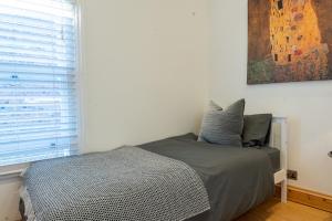 贝克斯利Bright & Comfy Single Room in Bexley Village的一间带床和窗户的小卧室