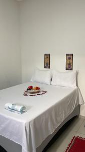 - un lit blanc avec une assiette de nourriture dans l'établissement Viver de Temporada Canindé- 10 Minutos de Piranhas- próximo aos principais pontos turísticos- vinho grátis e garagem para 3 carros, à Canindé de São Francisco