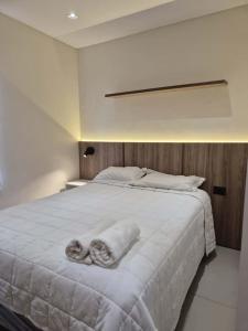 Una cama blanca grande con dos toallas encima. en Molas Tower 114B, en Asunción
