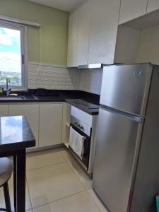 Una cocina con refrigerador de acero inoxidable y una mesa. en Molas Tower 114B, en Asunción