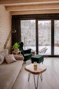 a living room with a couch and chairs and a window at Domki Momenty in Słajszewo